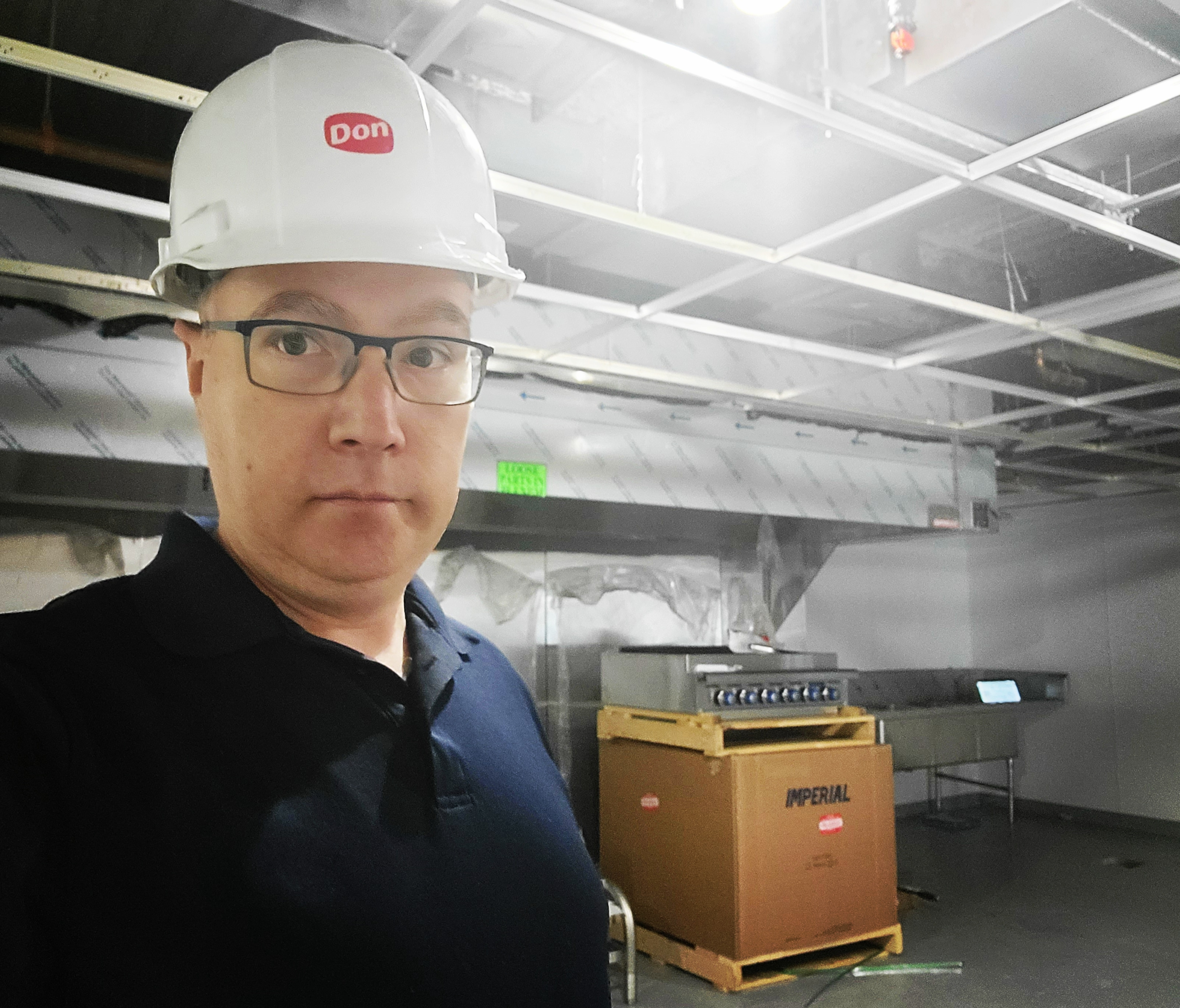 Drew Madden, commercial kitchen design consultant, on-site during a kitchen build wearing a hard hat